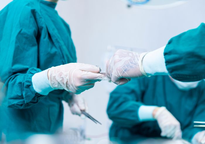 Zwei Menschen im OP übergeben sich etwas mit den Händen