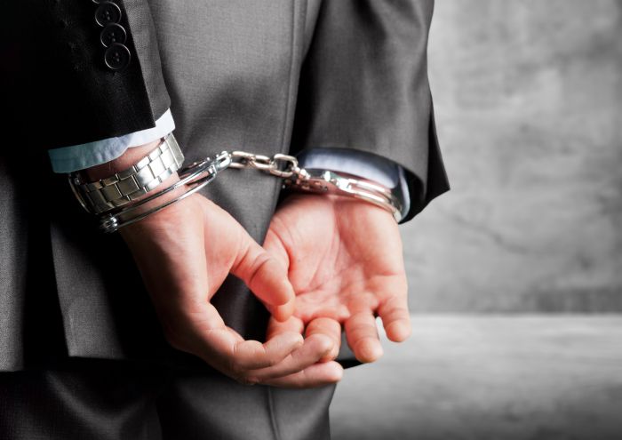 Hände hinter dem Rücken mit Handschellen